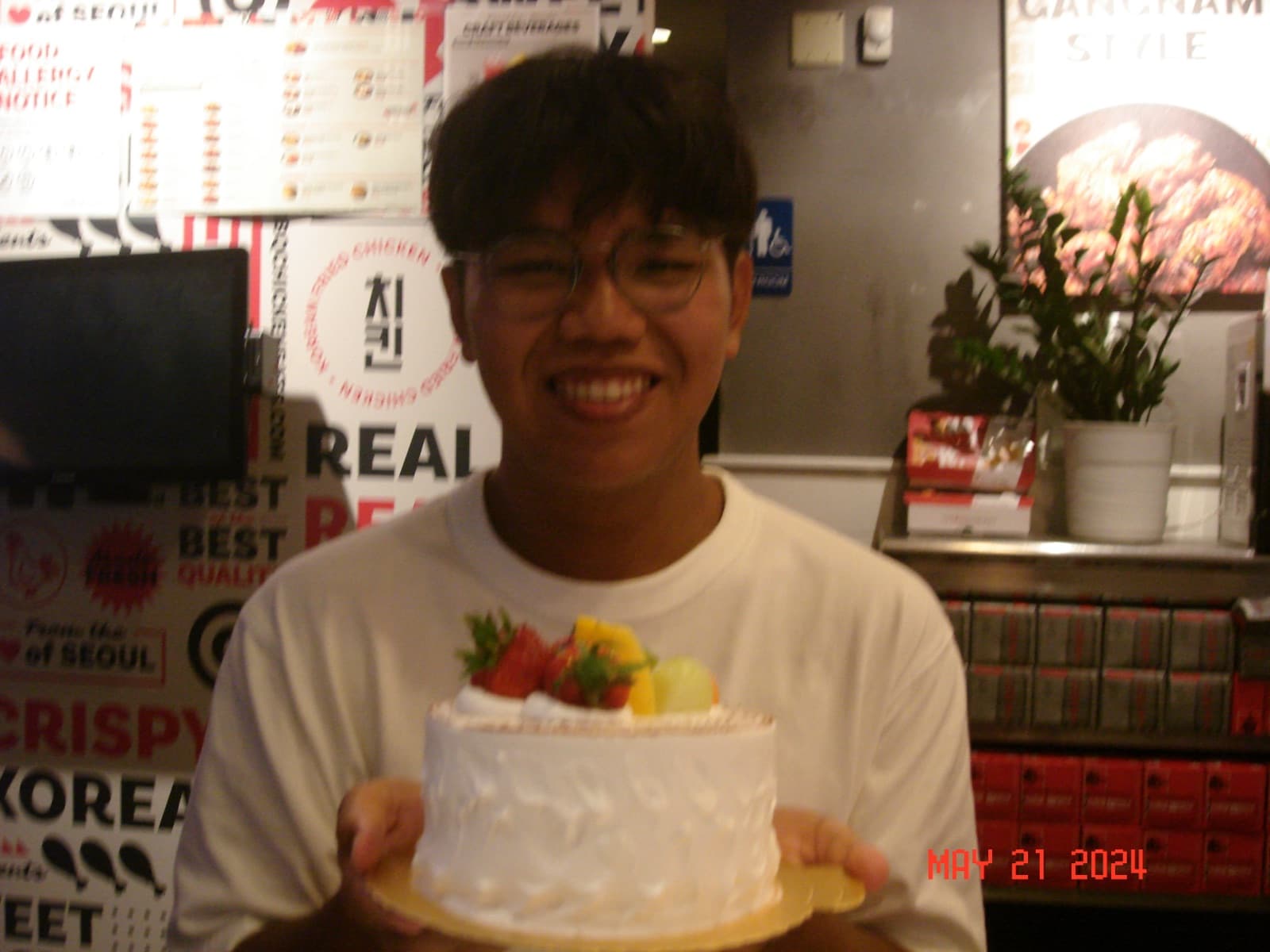 Erik grinning with a fruit-topped cream cake